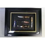A framed display of five Franklin Mint collectors knives, approximately 44 cm x 57 cm.