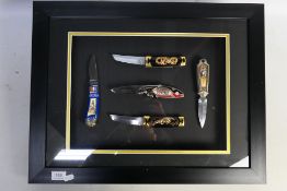 A framed display of five Franklin Mint collectors knives, approximately 44 cm x 57 cm.