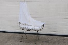 A wrought iron doll's berceau (cradle) with detachable valance holder and later lace valance,