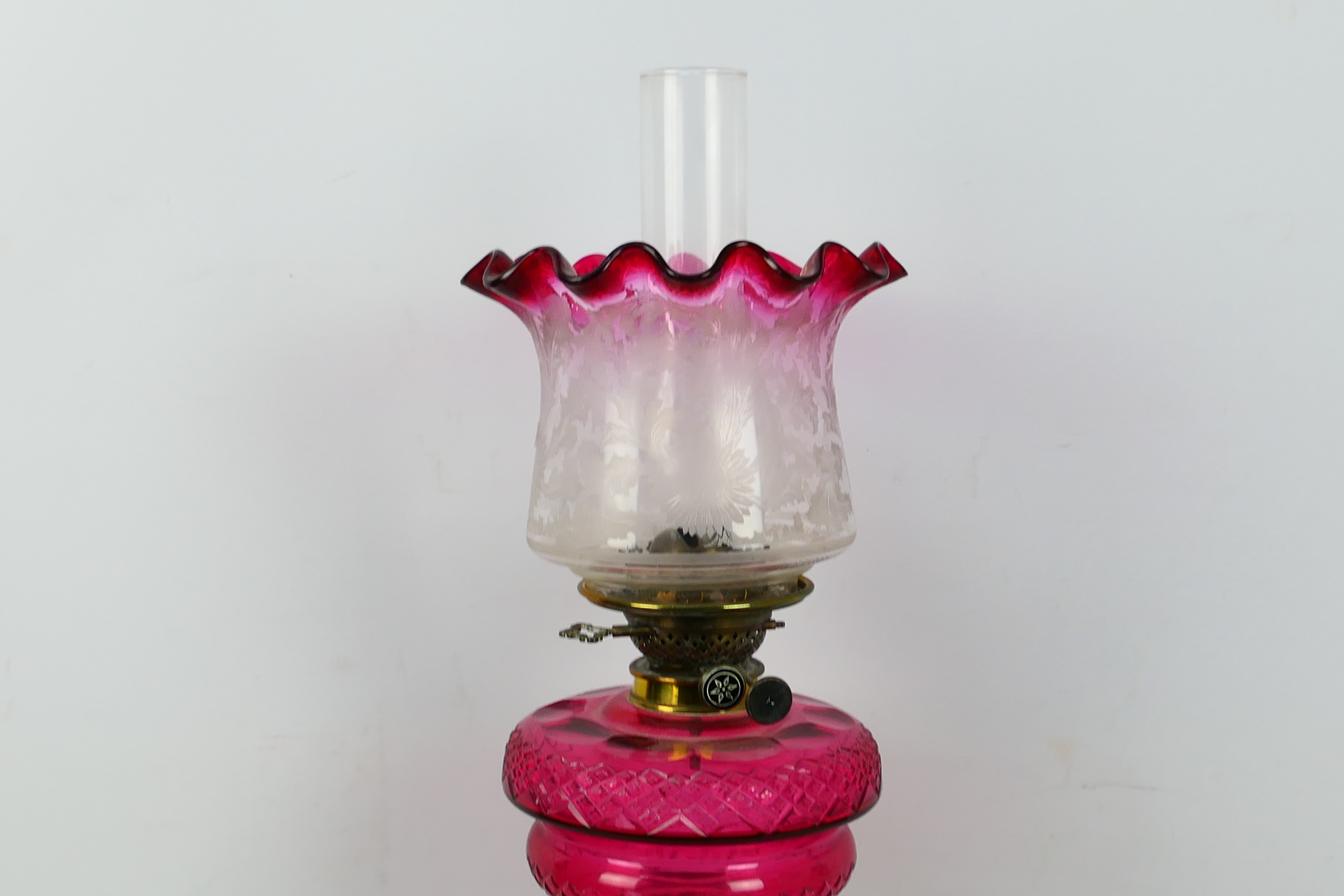 A brass oil lamp with cranberry glass font (font approximately 19 cm diameter) and cranberry tinted - Image 2 of 4