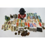 Lot to include a novelty money bank, Mdina paperweight, coins, tea cards, trinket box and similar.