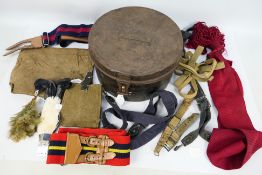 A naval cap tin containing various webbing, belts and similar.