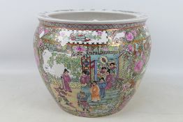 A large famille rose fish bowl decorated to the exterior with panels of court scenes / garden