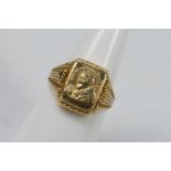 A yellow metal ring stamped 750 for 18ct, bearing image of Pío de Pietrelcina, size M+½,