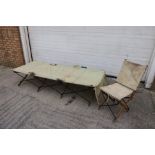 A WWII officers folding campaign bed and chair, of metal and wood construction with canvas supports,