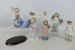 A collection of Nao figures of children including boy with a skateboard, girl with violin and other,