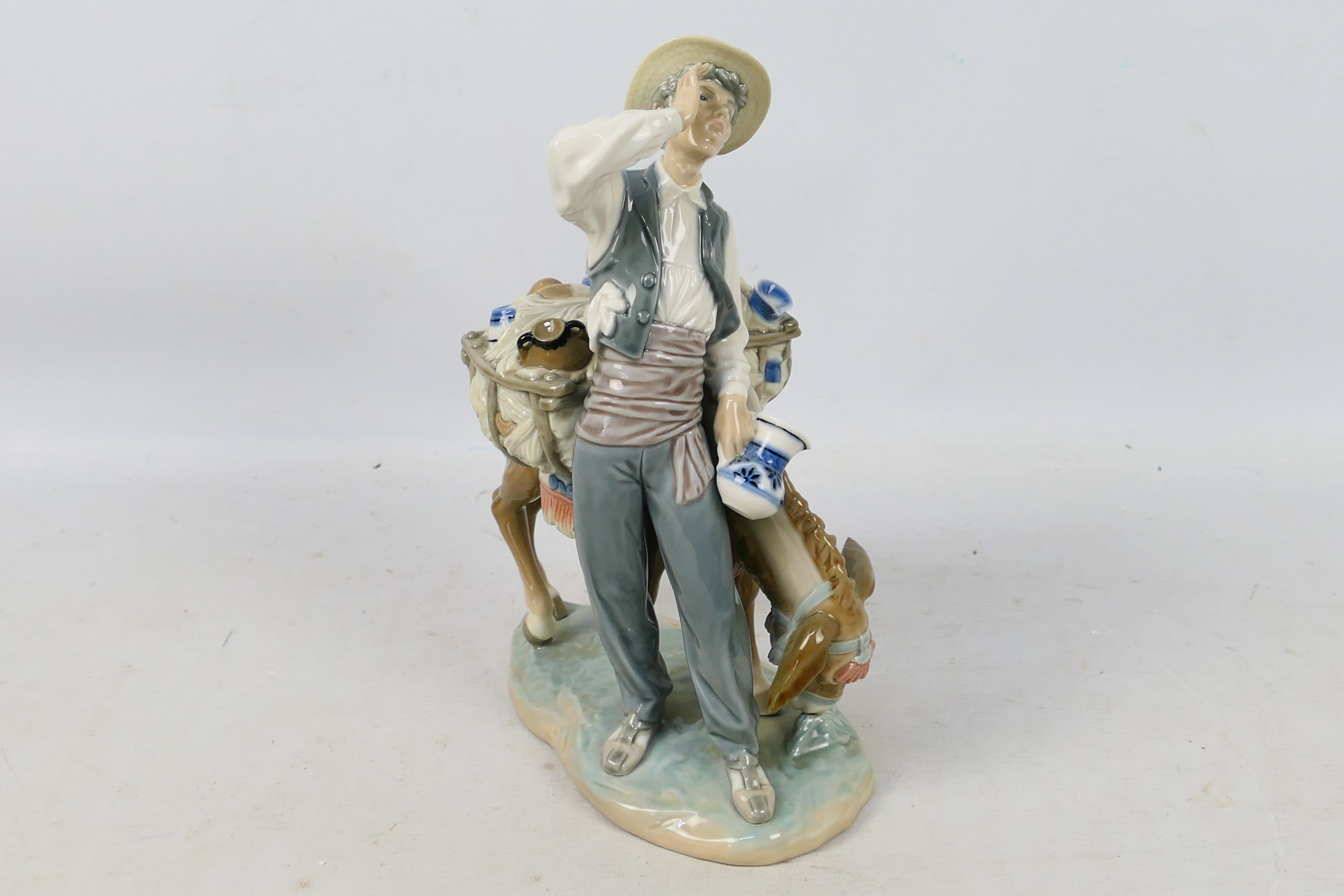 Lladro - A porcelain figural group entitled Peddler # 4859 depicting a pottery seller with his