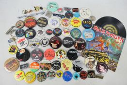 A collection of vintage pin badges, predominantly relating to music / rock bands,