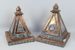 Two copper and white metal pyramids or altar displays with embossed decoration,