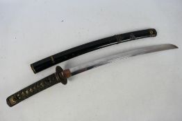 A vintage wakizashi with 45 cm blade, unsigned tang and plain iron tsuba with black lacquered saya,