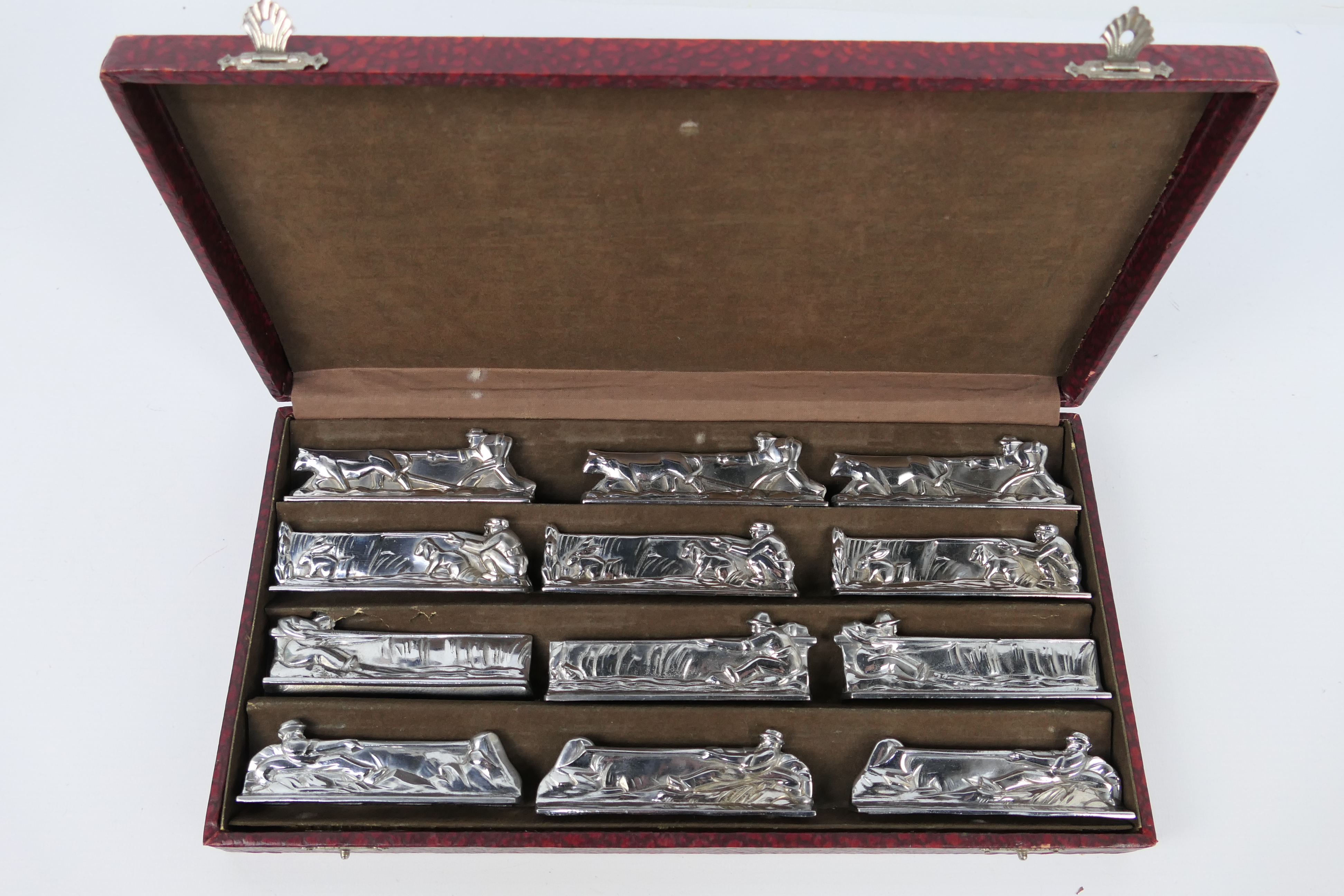 A set of twelve plated knife rests depicting hunting / farming scenes,