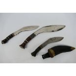 Three kukri knives, one contained in sheath.