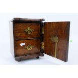 A small, two door, wooden jewellery box in the form of a safe,