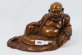 A wooden carving depicting Budai in reclining pose, approximately 18 cm (h),