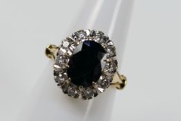 An 18ct yellow gold sapphire and diamond cluster ring, size M, approximately 5.