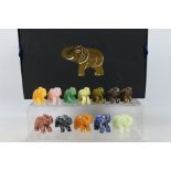 A collection of twelve carved elephants, each carved from a different hardstone,