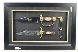 A framed display of three Franklin Mint collectors knives comprising two Bowie type knives and one