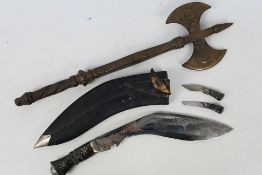 An Indian kukri knife with lion head pommel and leather scabbard and a decorative iron axe.