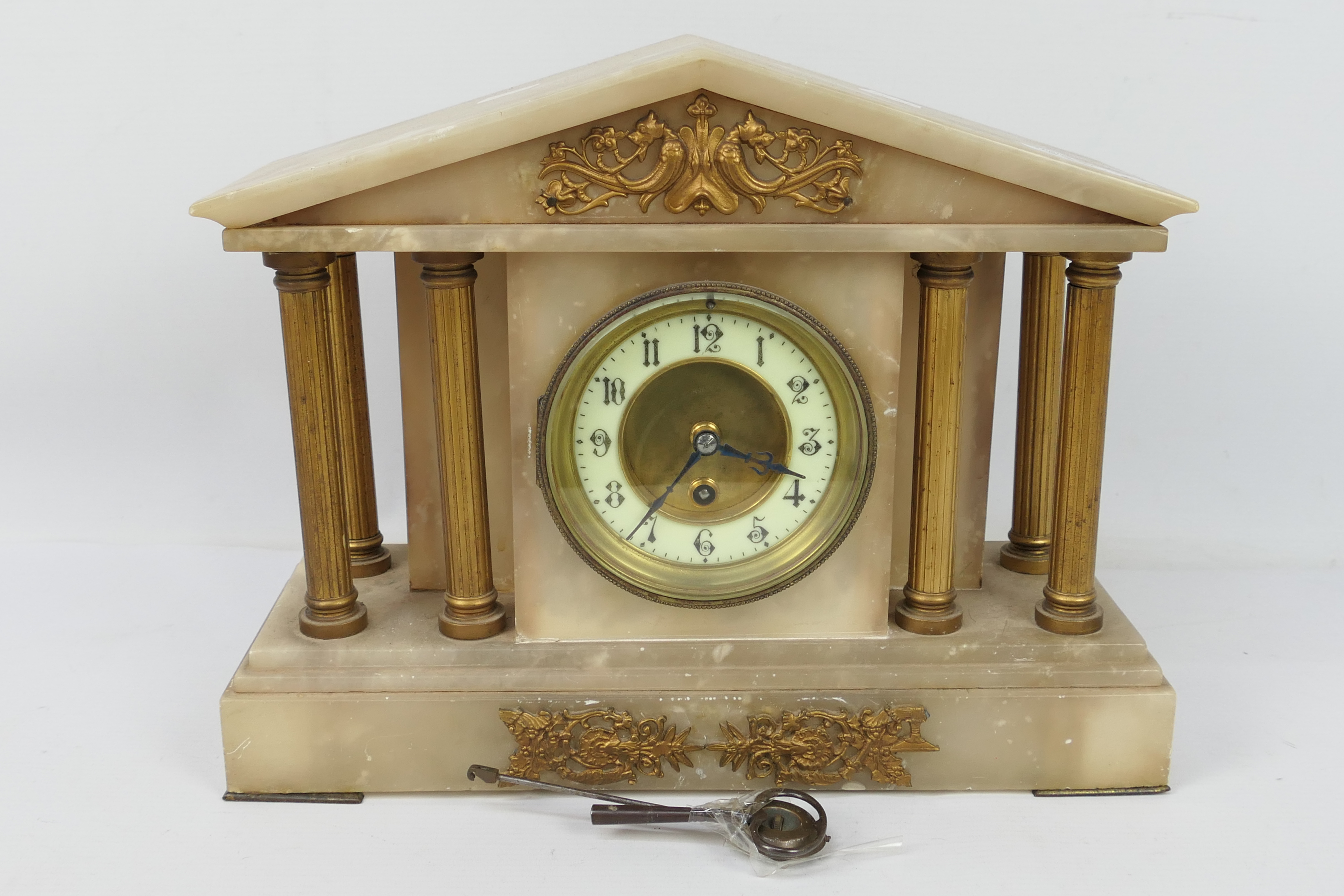 A mantel clock of architectural form, Arabic numerals to a white chapter ring,