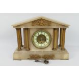 A mantel clock of architectural form, Arabic numerals to a white chapter ring,