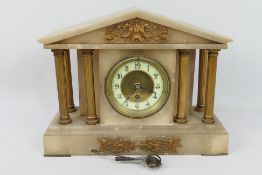 A mantel clock of architectural form, Arabic numerals to a white chapter ring,