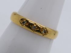 A hallmarked 22 carat gold ring set with three 5pt diamonds, approx 2.