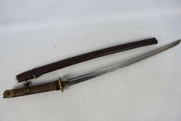 A vintage katana with 67 cm fullered blade, floral decorated tsuba, contained in leather clad saya,