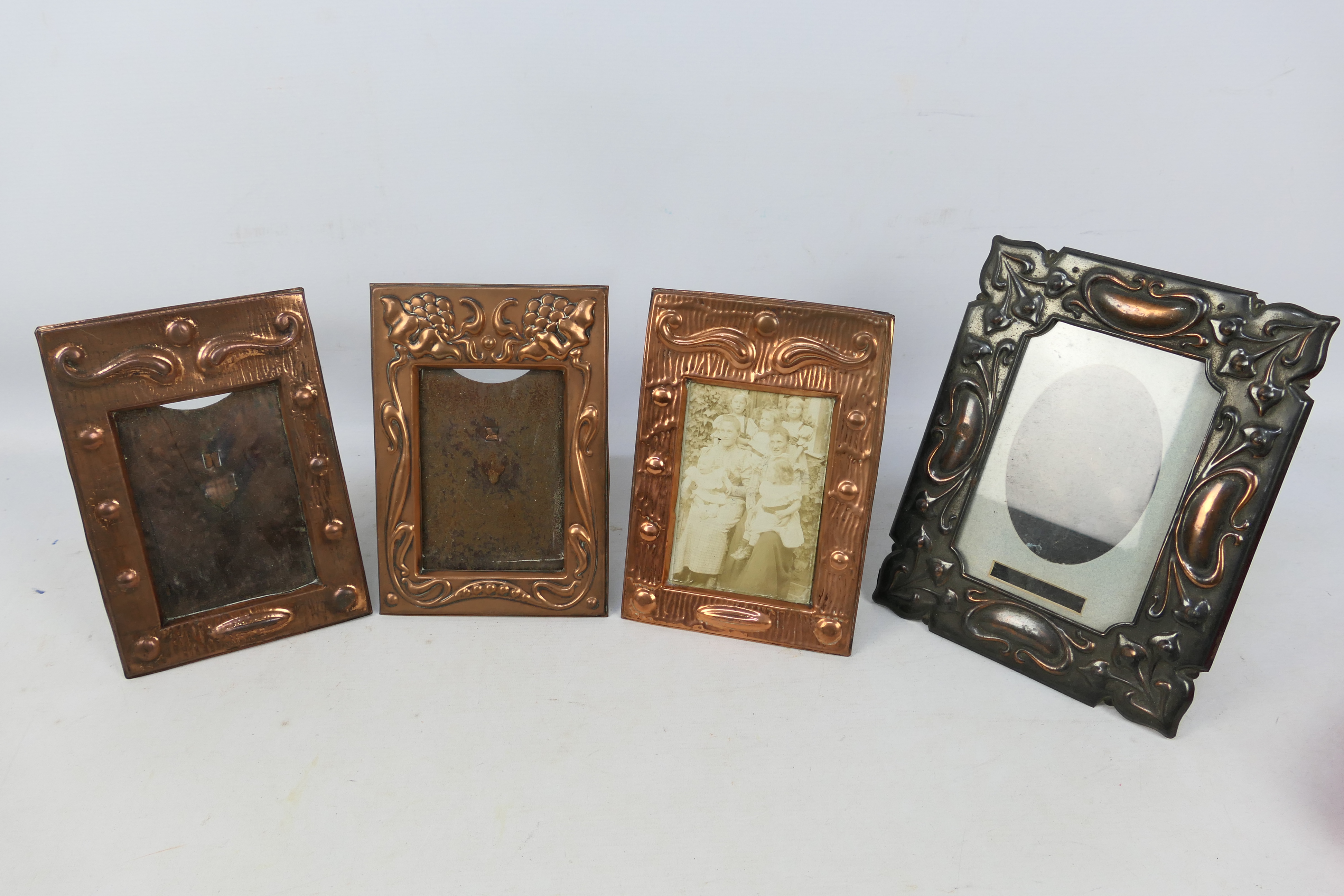 Four copper framed, easel back photograph frames including Art Nouveau style.
