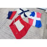 A collection of vintage maritime signal type flags, largest approximately 95 cm x 115 cm.