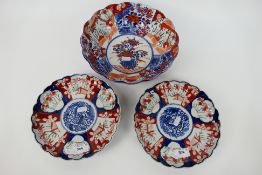 Three pieces of Imari ware comprising a bowl decorated with central basket of flowers,