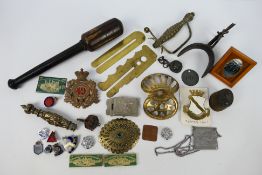Militaria to include wooden club, cap badges, lapel badges, spur, sword hilts and guards and other.