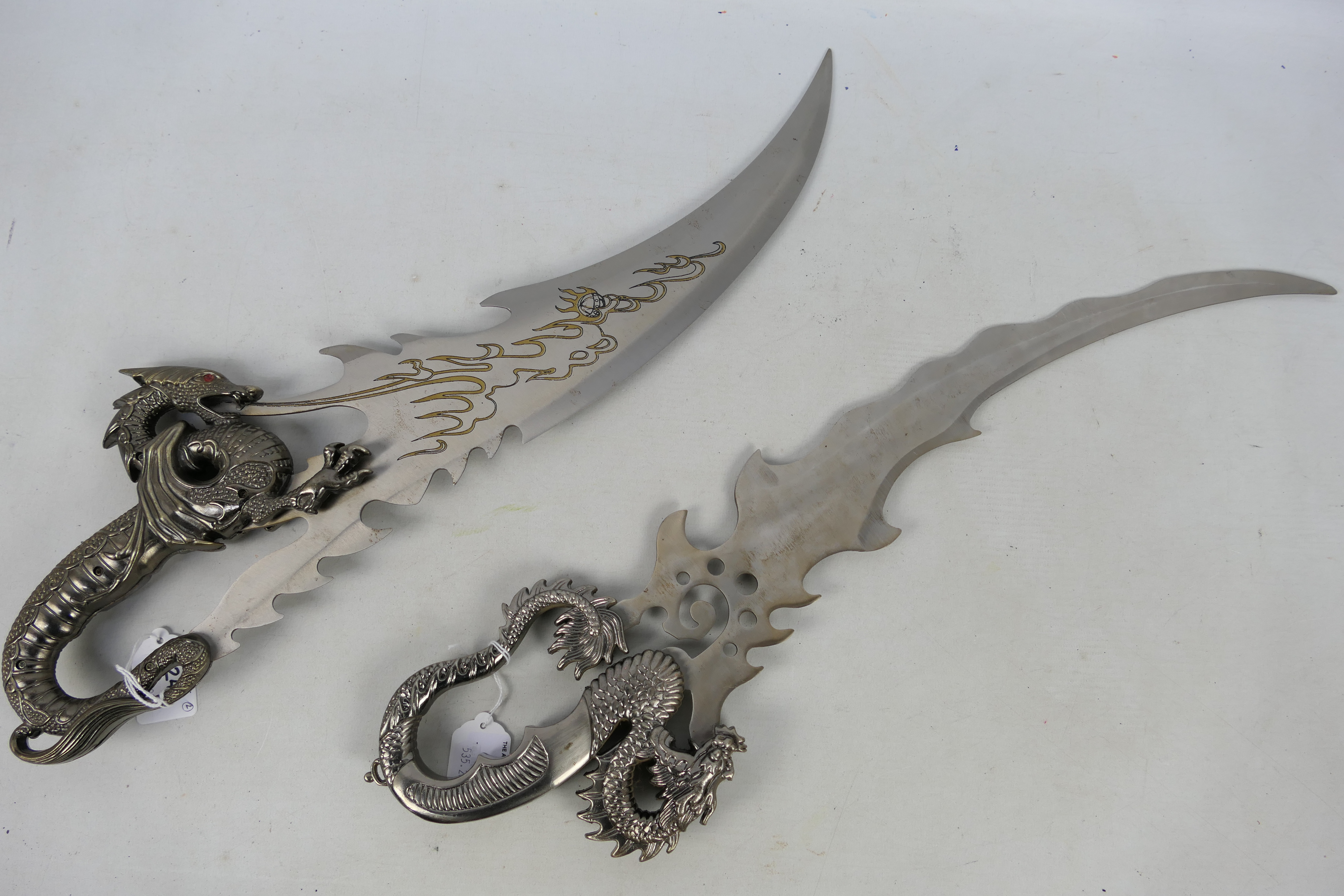 Two decorative Fantasy blades with dragon form hilts, approximately 55 cm (l).