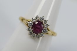 A yellow metal ruby and diamond cluster ring, stamped 0.750 for 18ct, size P, approximately 3.