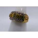 A 9ct yellow gold dress ring set with yellow, green and white stones, size N, approximately 6.