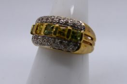 A 9ct yellow gold dress ring set with yellow, green and white stones, size N, approximately 6.