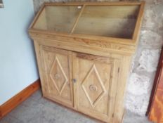 A good pine cabinet with hinge-lidded display area above, and shelved area below,