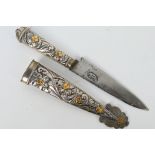 A white and gilt metal Argentinian Gaucho knife with floral decorated hilt and scabbard,