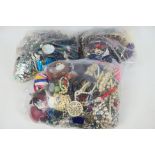 Three clear bags containing a collection of unsorted costume jewellery, approximately 16 kg.