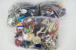 Three clear bags containing a collection of unsorted costume jewellery, approximately 16 kg.