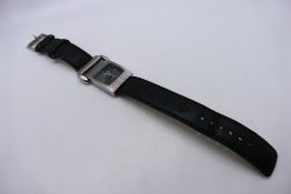 A lady's fashion watch, marked Gucci to the black dial, on black leather strap.