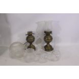 Bates Brass of Birmingham - Two brass oil lamps with 7 x detached various mostly patterned glass