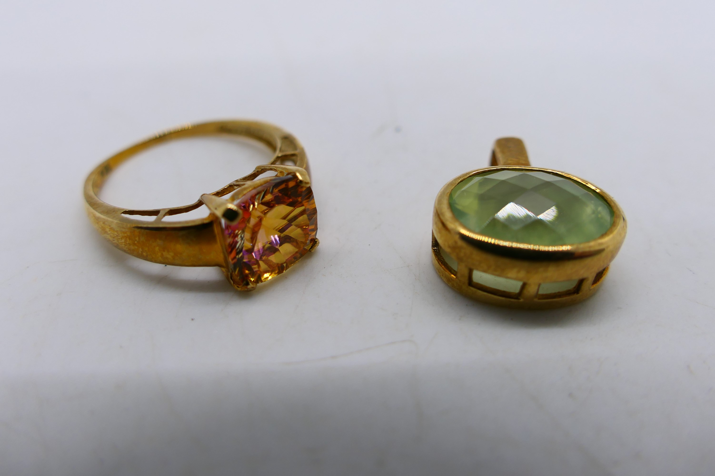 A 9ct gold stone set dress ring, size O+½, 2.3 grams and a stone set yellow metal pendant.