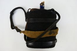 A World War One British army blue enamel water bottle, the leather holster dated 1918.