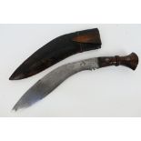 A Gurkha kukri knife, dated 1916, turned wooden hilt with metal pommel, housed in leather sheath.