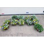 A collection of 11 x hanging flower baskets, all with fake flowers. All appear in good condition.