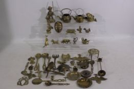 A collection of brass items to include a bird, mask, elephant, and similar.