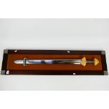 A decorative sword display with viking style sword mounted to display board,