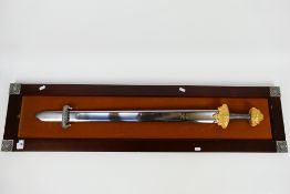 A decorative sword display with viking style sword mounted to display board,