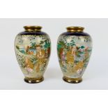 A pair of Japanese Satsuma ware vases decorated with two panels of figures in a garden setting