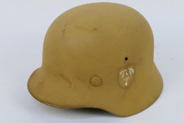 A reenactors German Afrika Korps stahlhelm with liner and chin strap.